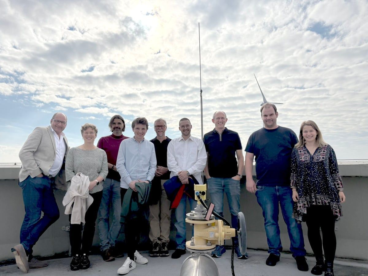Gruppenfoto von neun Personen auf einem Dach neben einer Messstation